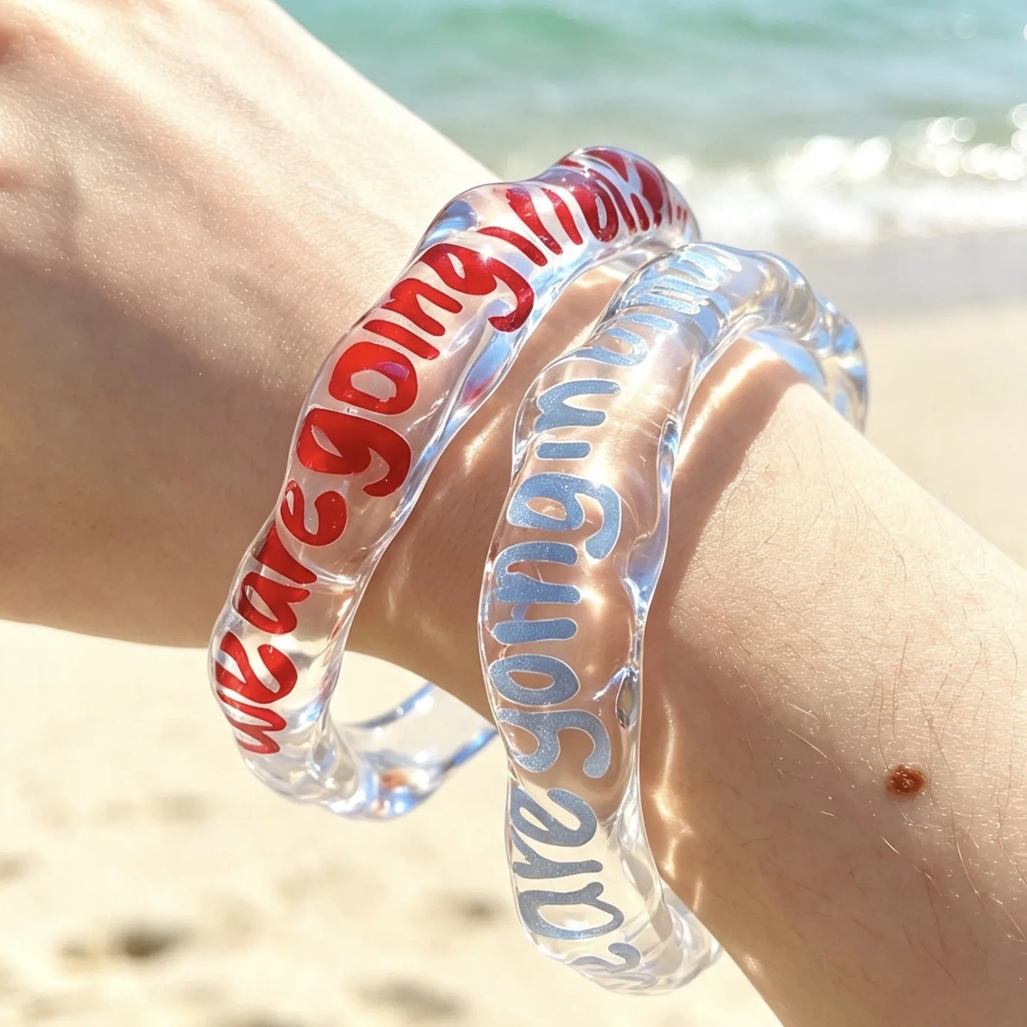 Close-up of personalized transparent resin bracelet with custom printed lettering.