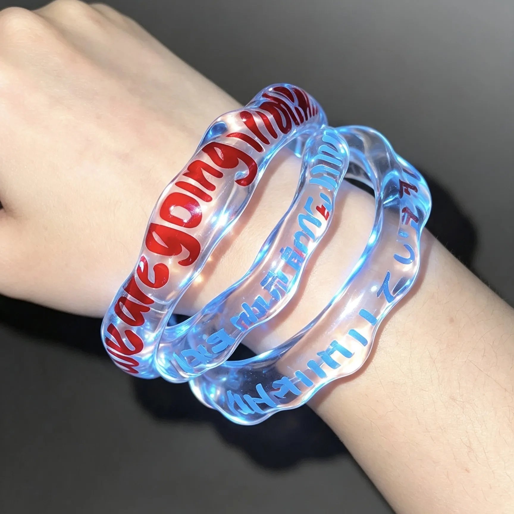 Model wearing a personalized transparent acrylic bracelet with custom lettering.
