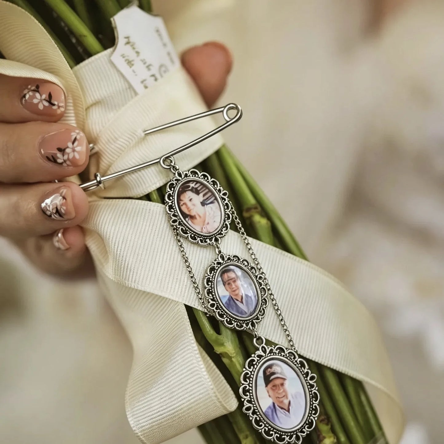 Close-up of handcrafted wedding photo charms with personalized family portraits.