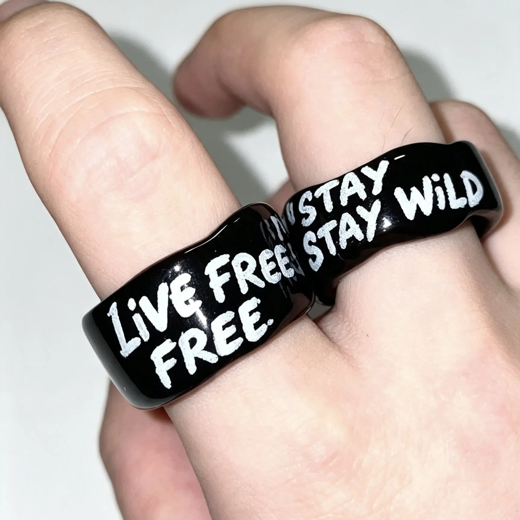 Matching personalized ceramic rings with custom engraved messages for couples.