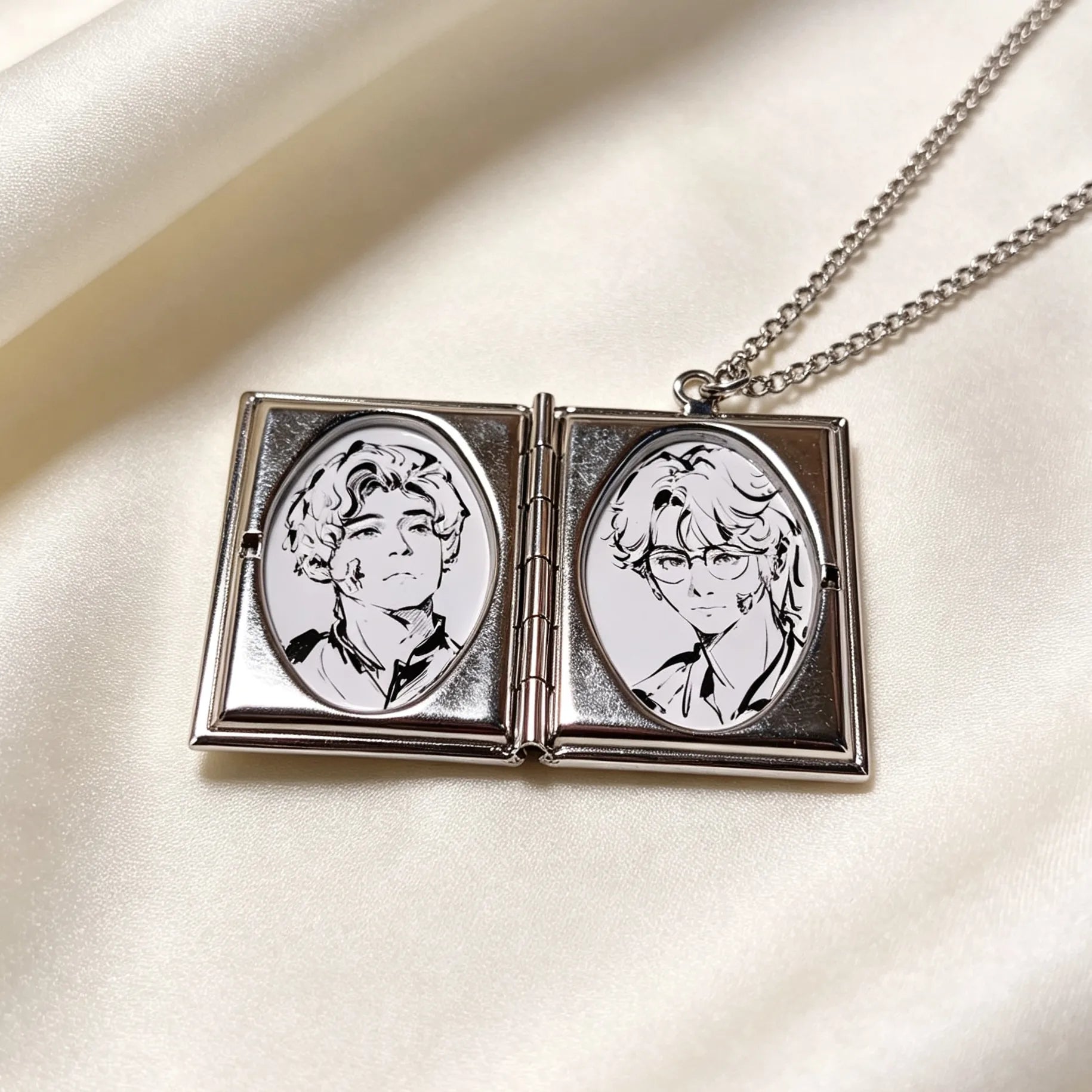 Mini book-style pendant featuring two personalized photo inserts inside a silver locket necklace.
