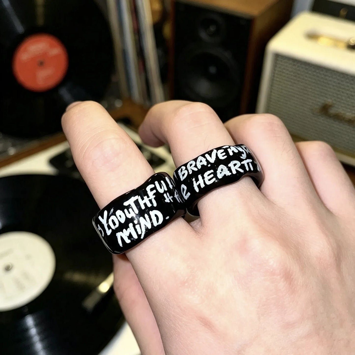 Model wearing a personalized black ceramic ring with custom inspirational quote.